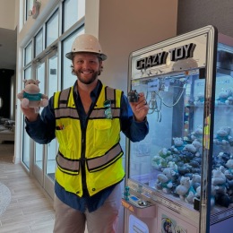 man in a construction vest holding a plush toy